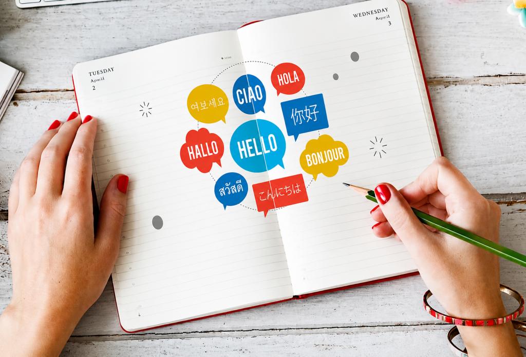Notebook displaying greetings in multiple languages, illustrating multilingual communication and overcoming language barriers in healthcare.
